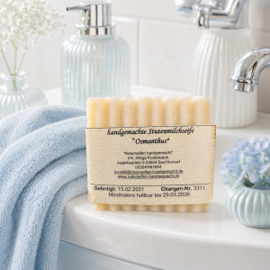 Eine geriffelte, quadratische handgemachte Stutenmilchseife mit dem Duft Osmanthus, stehend im Badezimmer